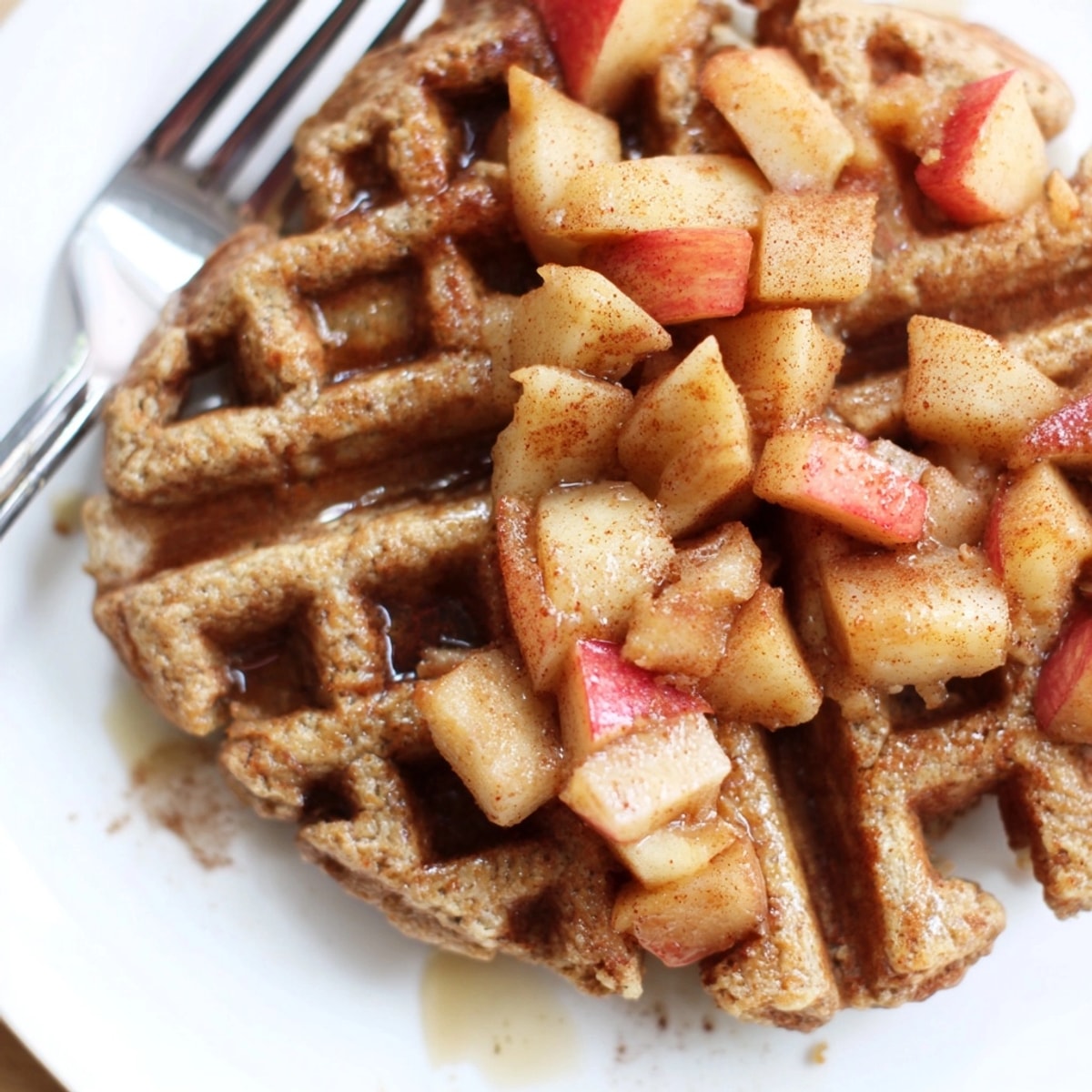 Golden Cinnamon Apple Protein Waffles steaming, ready to be enjoyed with maple syrup.