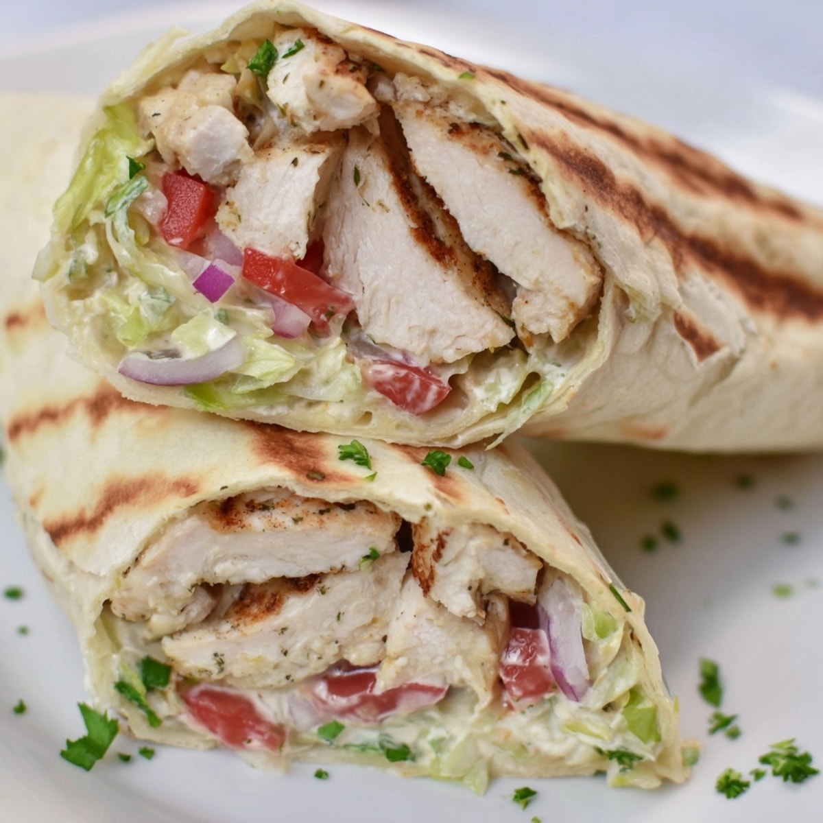 Close-up shot of folded Garlic Herb Chicken Alfredo Wraps, oozing with creamy sauce.