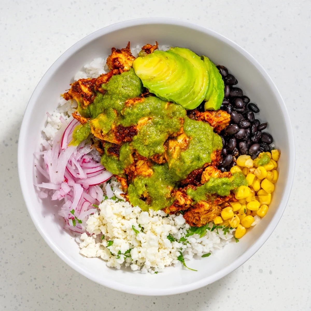 Green Enchilada Rice Bowl overflowing with chicken, black beans, and vibrant toppings, ready to eat.
