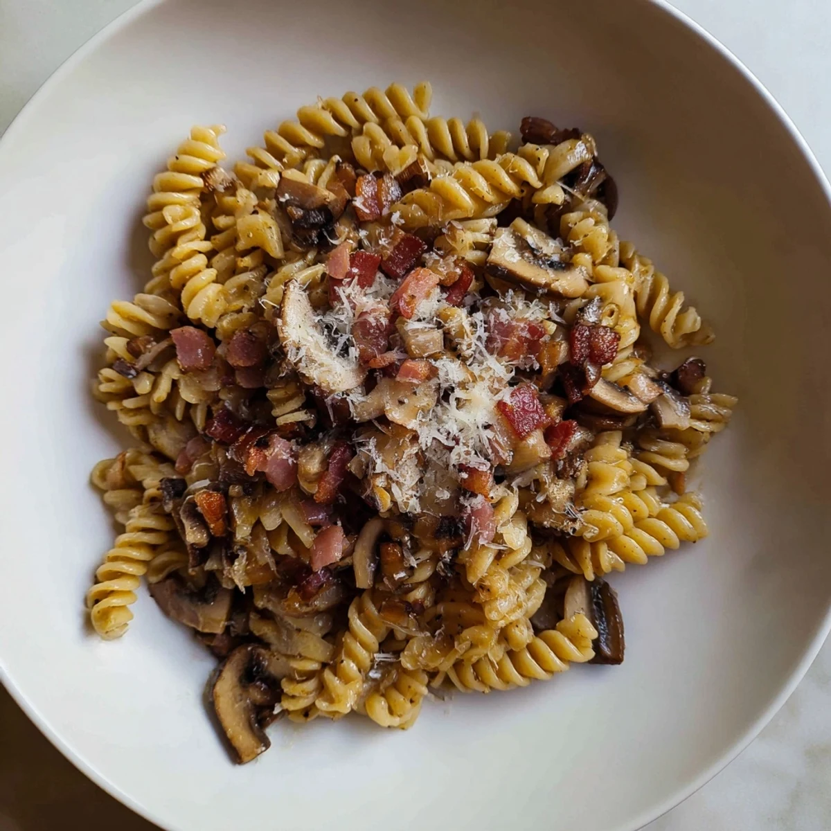 Earthy mushrooms and savory bacon mingle with perfectly cooked fusilli in this delicious dish.