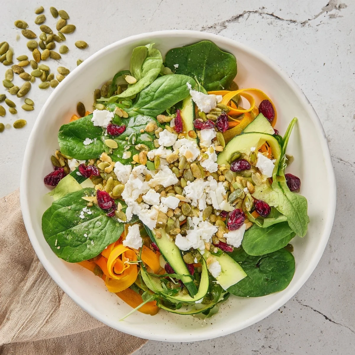 A beautifully layered Pistachio and Cranberry Salad, showing vibrant greens, reds, and golden squash ribbons, ready to serve.