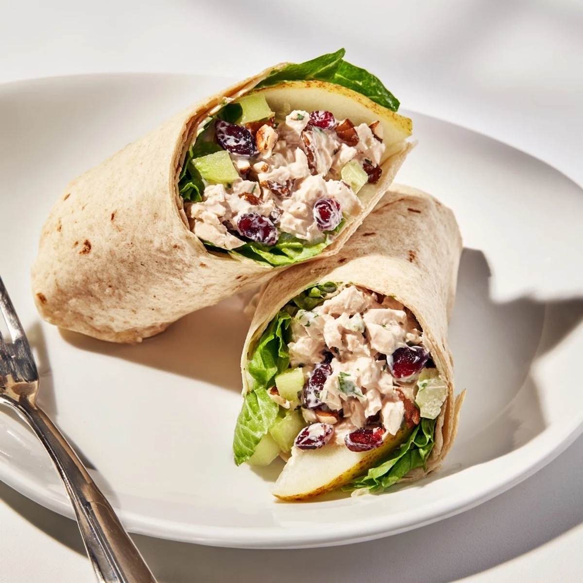Creamy Cranberry Pecan Chicken Salad Christmas Wrap, ready to eat, with colorful greens peeking out.