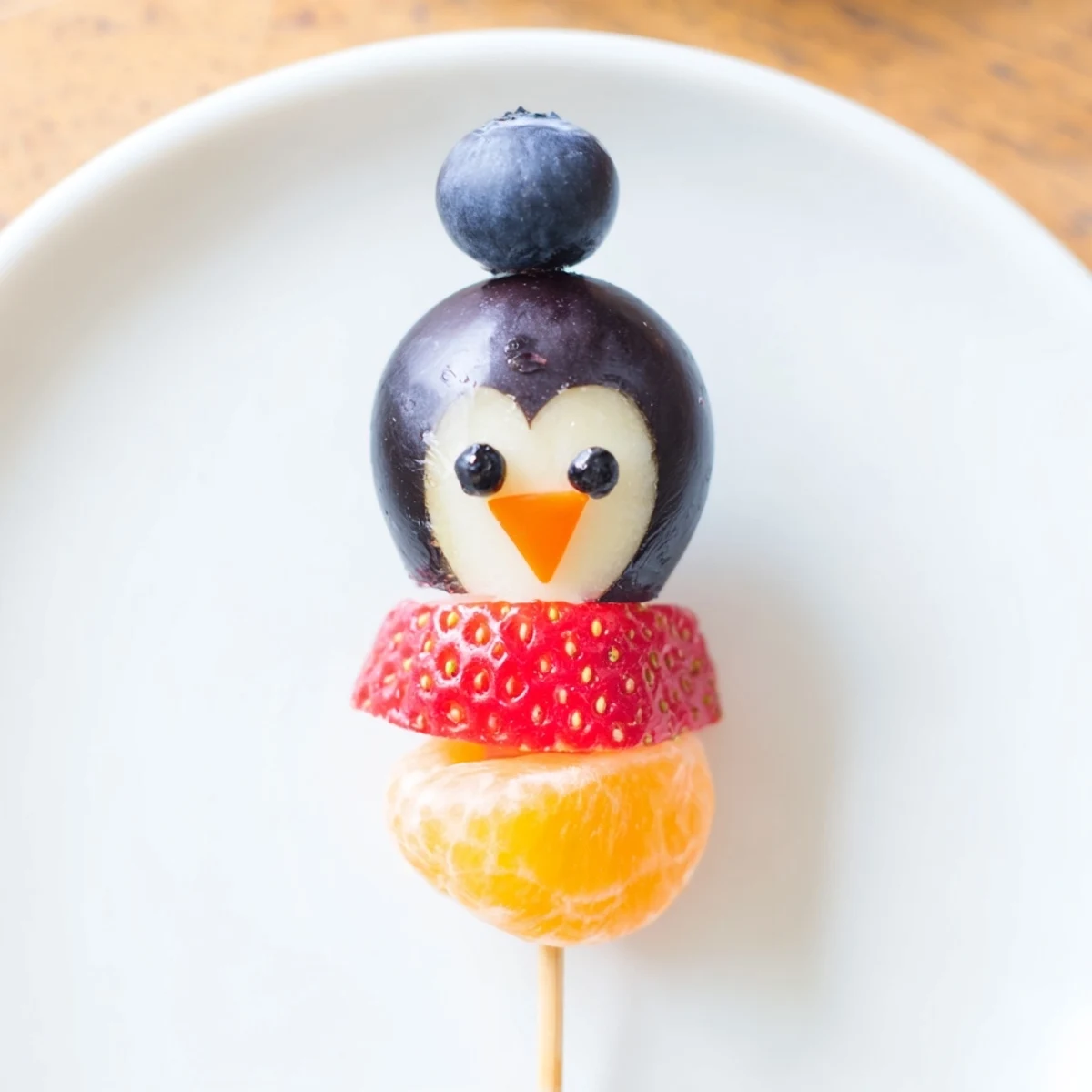 Penguin Fruit Skewer Army: Colorful strawberries, grapes, and oranges create a fun, healthy snack displayed perfectly.