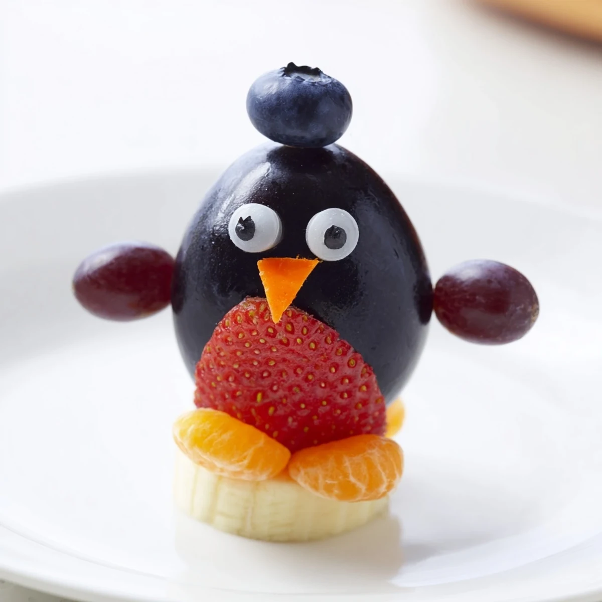 Playful Penguin Fruit Skewer Army featuring strawberries and grapes, perfect for a kids' party treat.