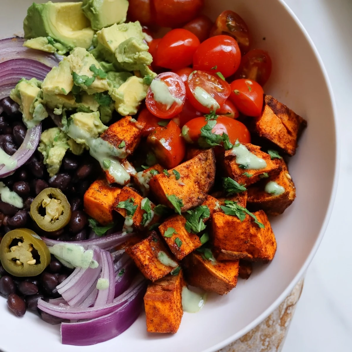 Savory sweet potato taco bowls, overflowing with roasted veggies and topped with fresh cilantro.