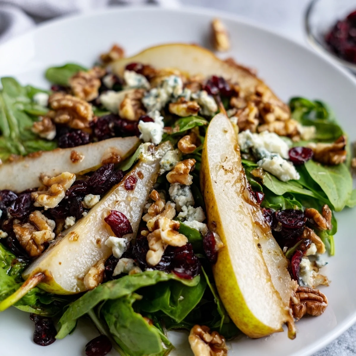 Vibrant slices of ripe pear, crumbled Gorgonzola, and toasted walnuts on mixed greens, drizzled with honey-balsamic vinaigrette for a refreshing salad.  