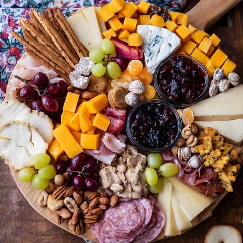 Vibrant Christmas 2025 Board: a festive arrangement of cheeses, meats, fruits, and crackers perfect for your guests.
