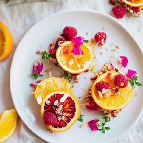 Elegant Baisers de Minuit cocktail garnishes with vibrant pomegranate and raspberry skewers, ready to serve.