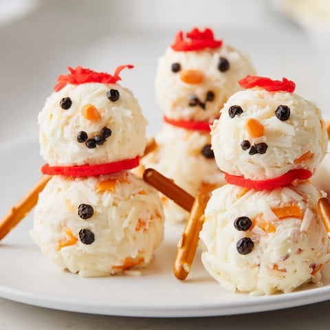 A delightful Snowman Cheese Ball Trio, perfect for a festive appetizer, ready to eat.