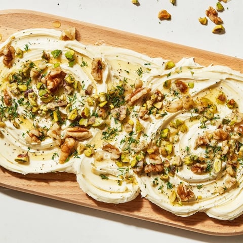 Flavorful butter board charcuterie with chopped nuts, herbs, and honey is ready to share.