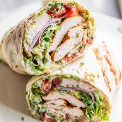 Golden grilled chicken pieces nestled in a warm Garlic Herb Chicken Alfredo Wrap.