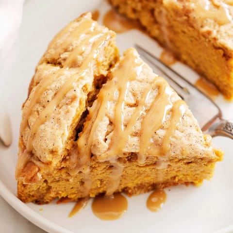 Indulge in creamy Chai Pumpkin Sweet Tea Cheesecake Cake Scones drizzled with sweet glaze.  