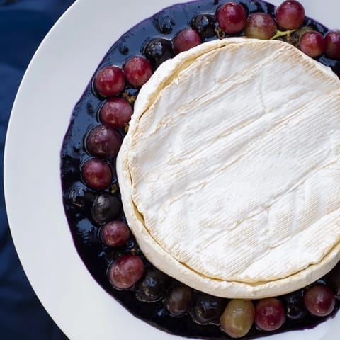 Eye-catching Floating Island: a visually stunning party platter of cheese, vibrant blue dip, and grapes.