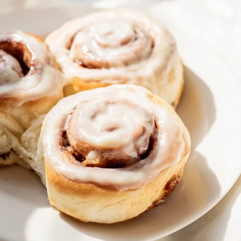 A close-up of Pillow Soft Cinnamon Rolls reveals their fluffy texture and enticing cinnamon sugar filling.