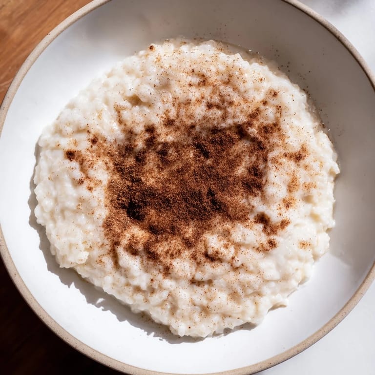 Enjoy a comforting serving: homemade chilled Rice Pudding with Leftover Rice, aromatic cinnamon, and sweet flavors.