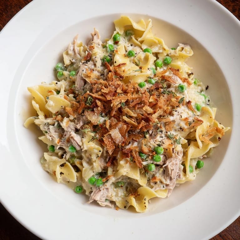 This image shows a freshly baked Tuna Noodle Casserole, topped with crispy onions, ready to serve!
