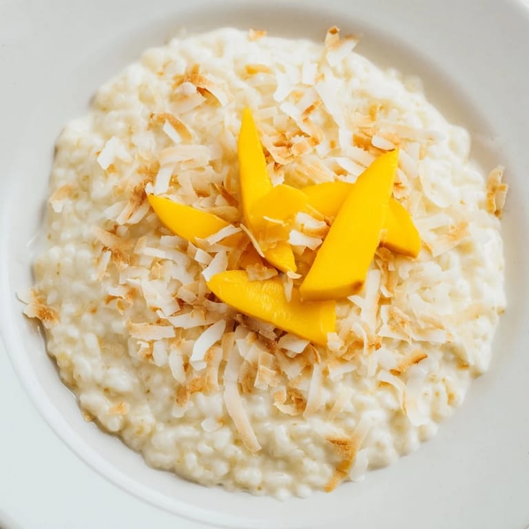 A bowl of delicious toasted coconut rice pudding, ready to be enjoyed with fresh tropical fruit.