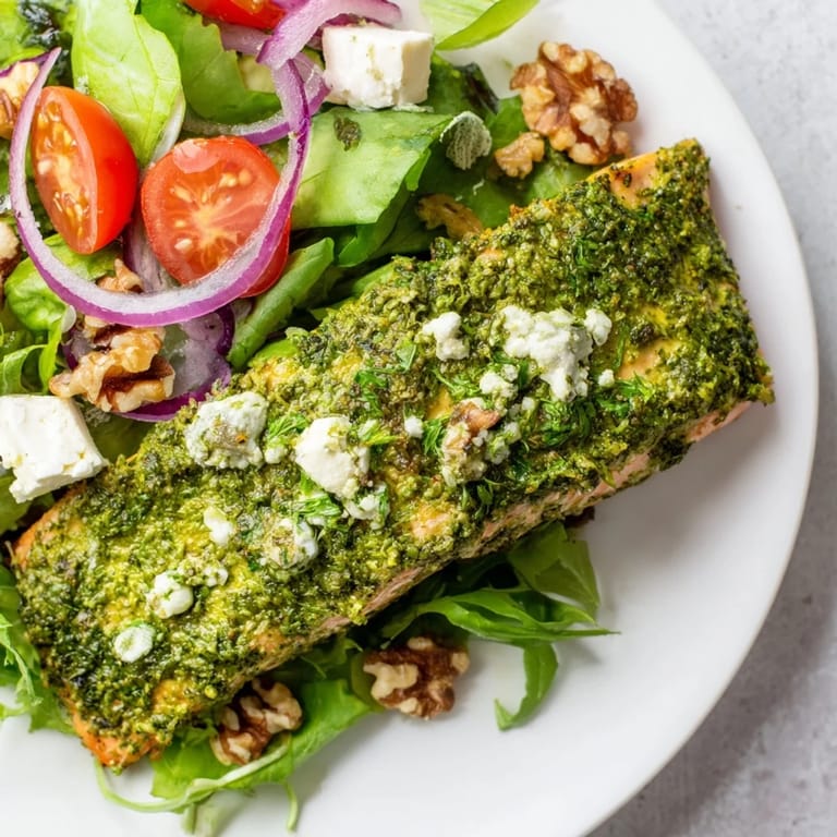 A close-up view of the delicious herb-crusted salmon salad, with colorful tomatoes and cucumber.