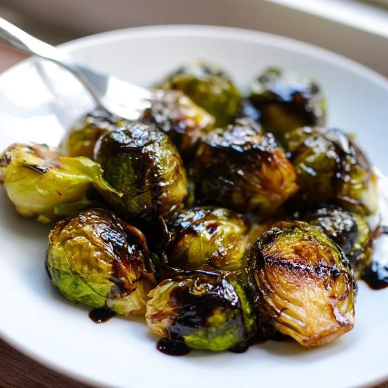 Roasted Brussels sprouts served warm with a sweet balsamic drizzle, perfect for a holiday side dish.