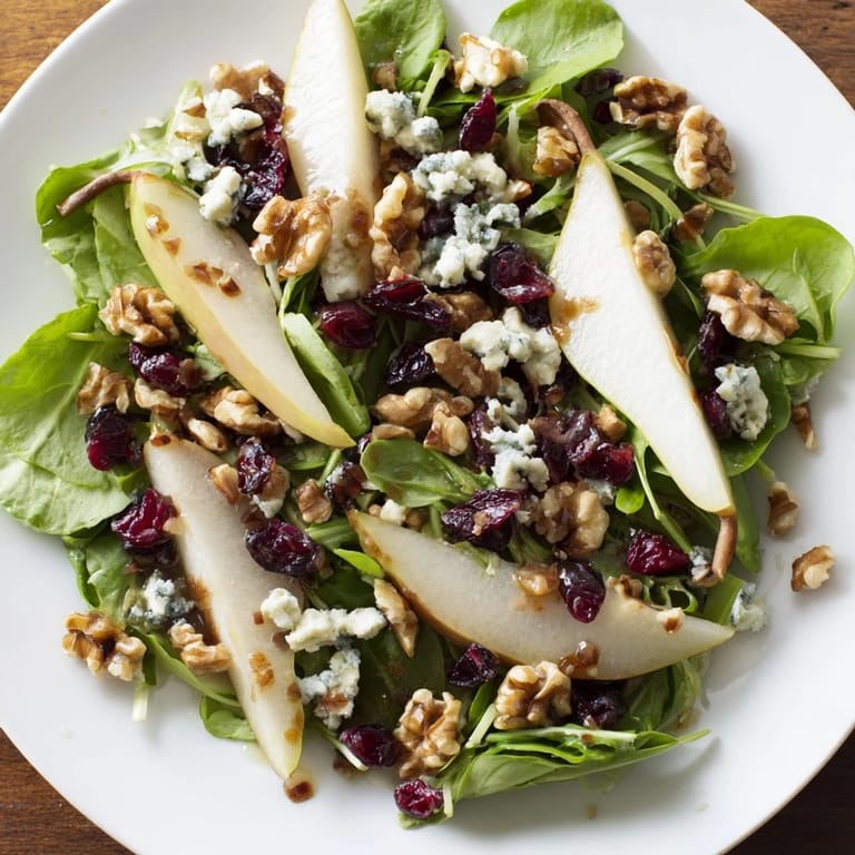 Lush pear slices, Gorgonzola crumbles, and walnuts on salad greens, with honey-balsamic dressing ready to serve as a light, vegetarian meal.